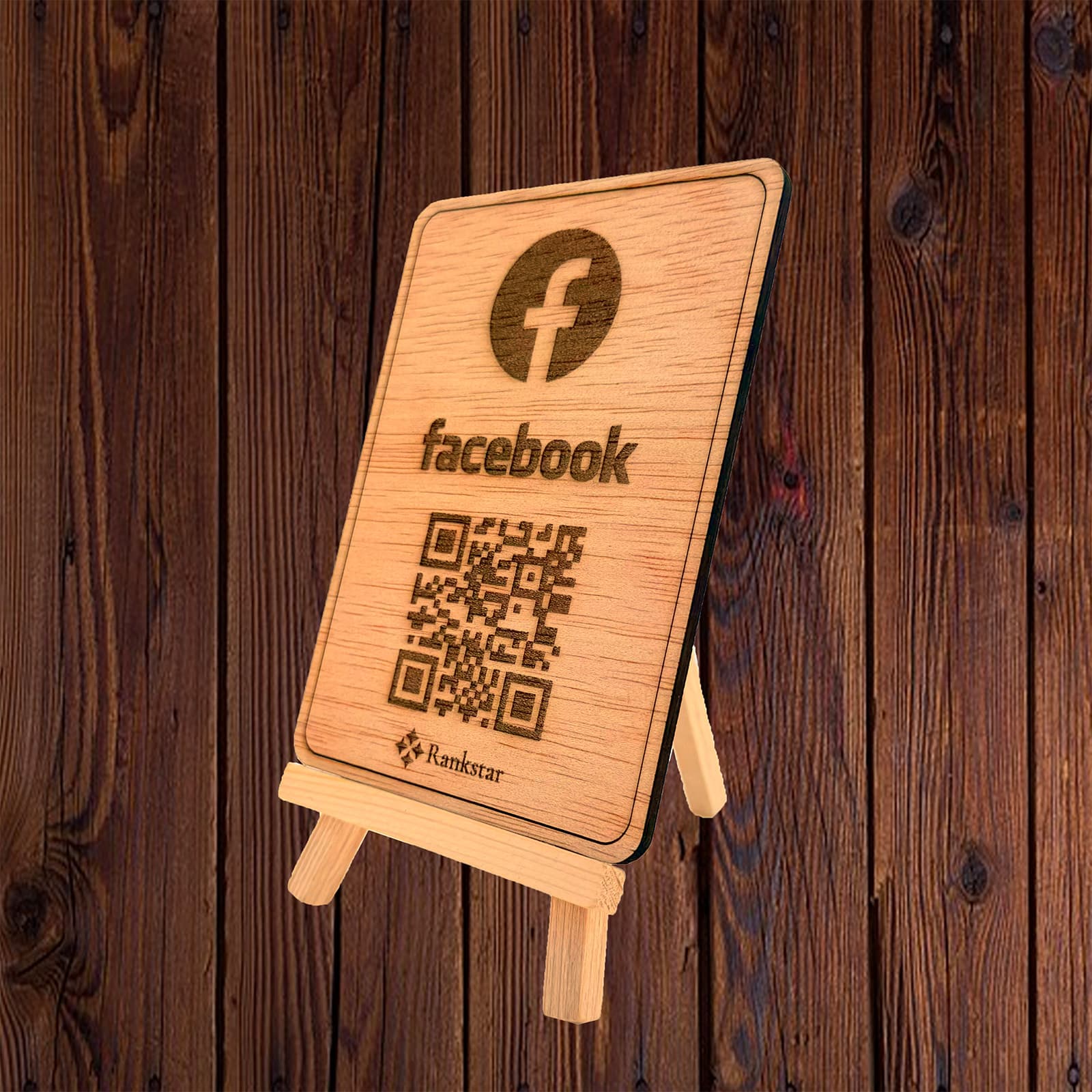 Expositor Rankstar de madera sobre su caballete, con el logo de Facebook y el QR grabado a láser, sobre un fondo de madera oscura