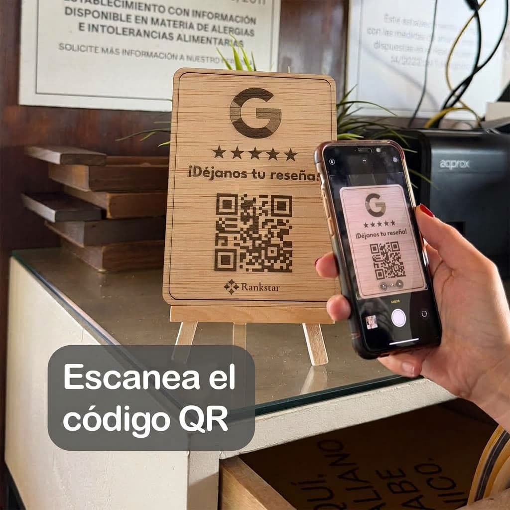 Un cliente escanea con el móvil el QR del expositor Rankstar de Google sobre el mostrador de un local
