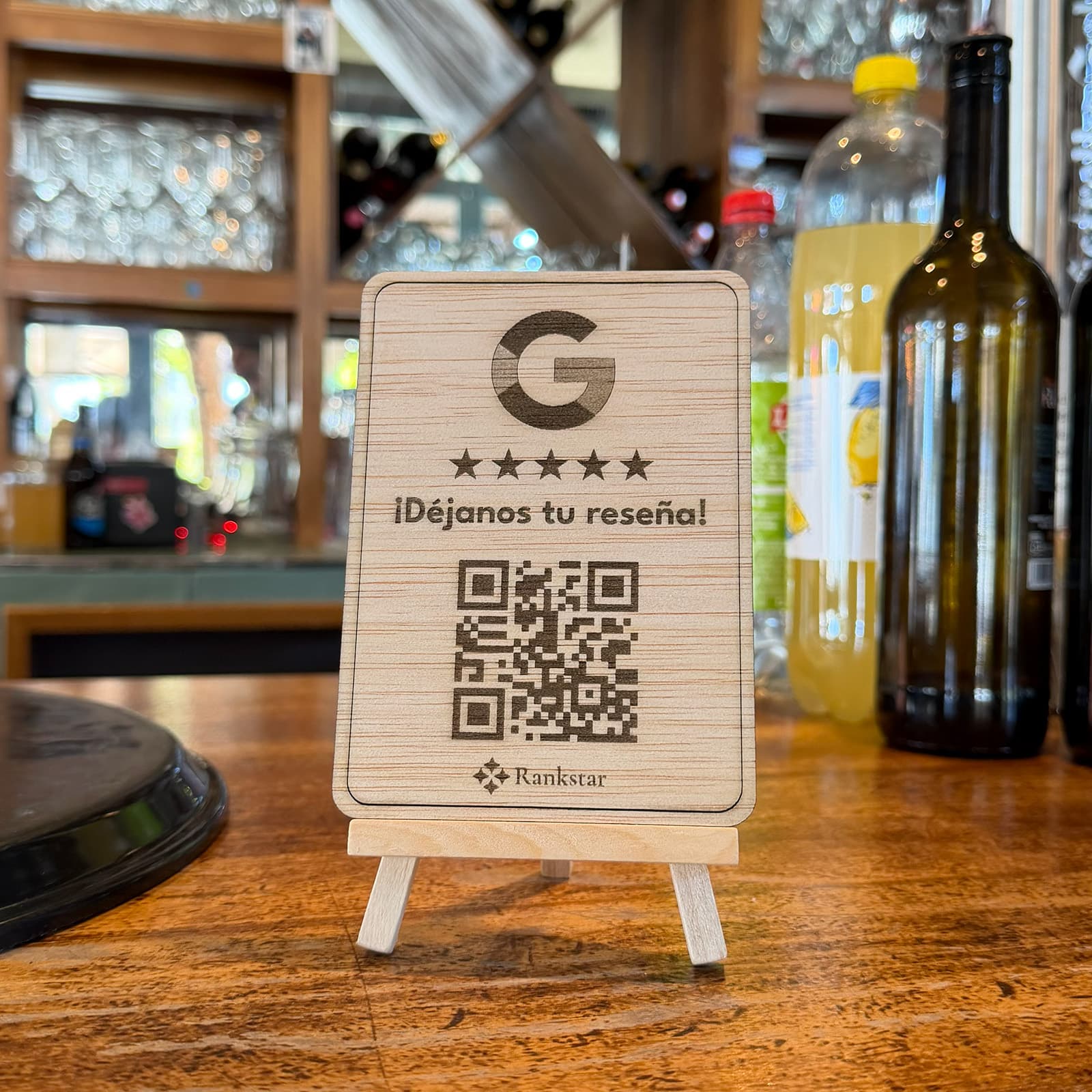 Expositor Rankstar de Google en la barra de un bar, con botellas y estantes de copas detrás