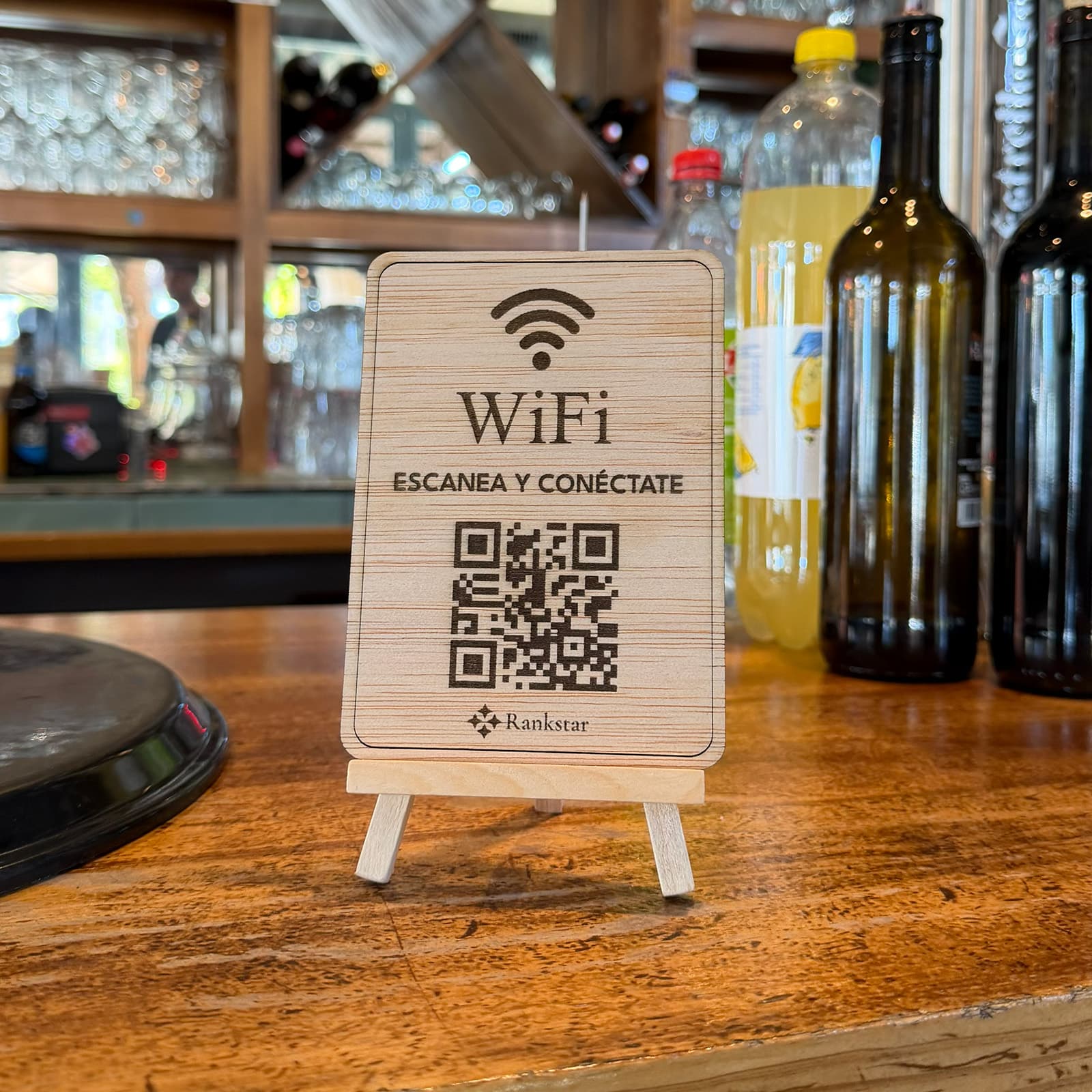 Expositor Rankstar de WiFi en la barra de un bar, entre las botellas y las copas