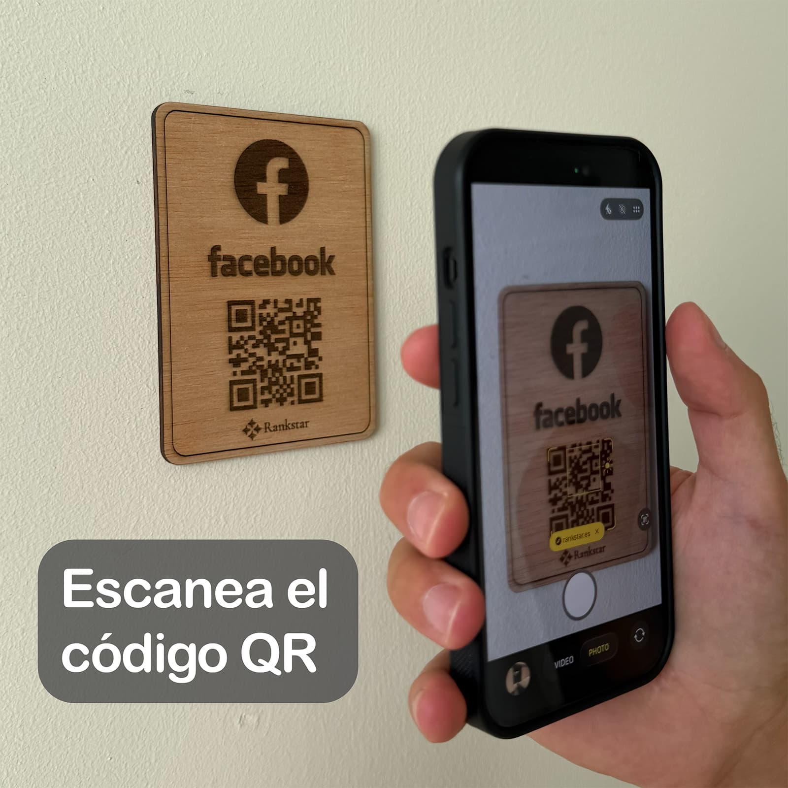 Una mano escanea con el móvil el QR de la placa Rankstar de Facebook pegada en una pared, con el rótulo «Escanea el código QR»