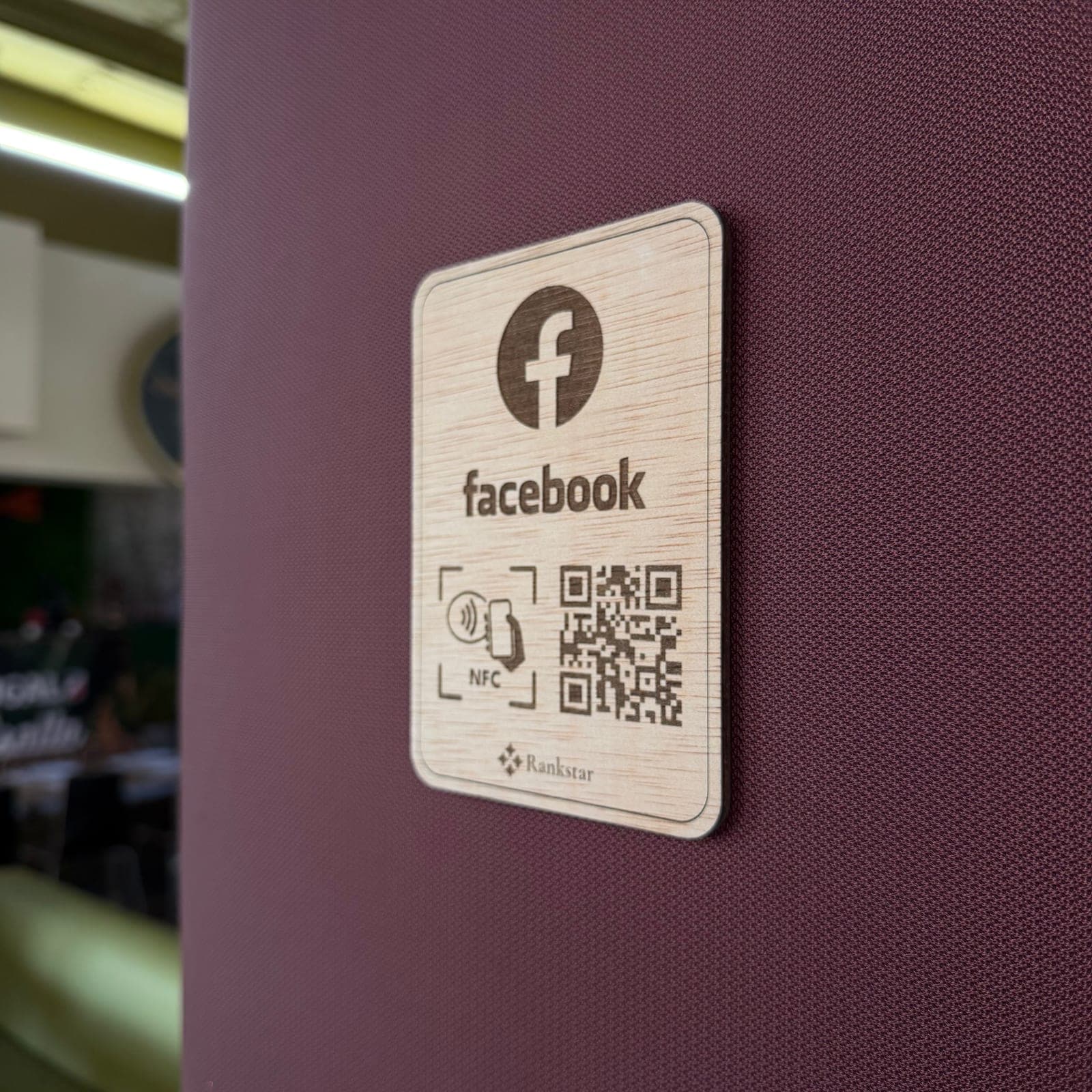 Placa Rankstar de Facebook pegada en la pared granate de un restaurante