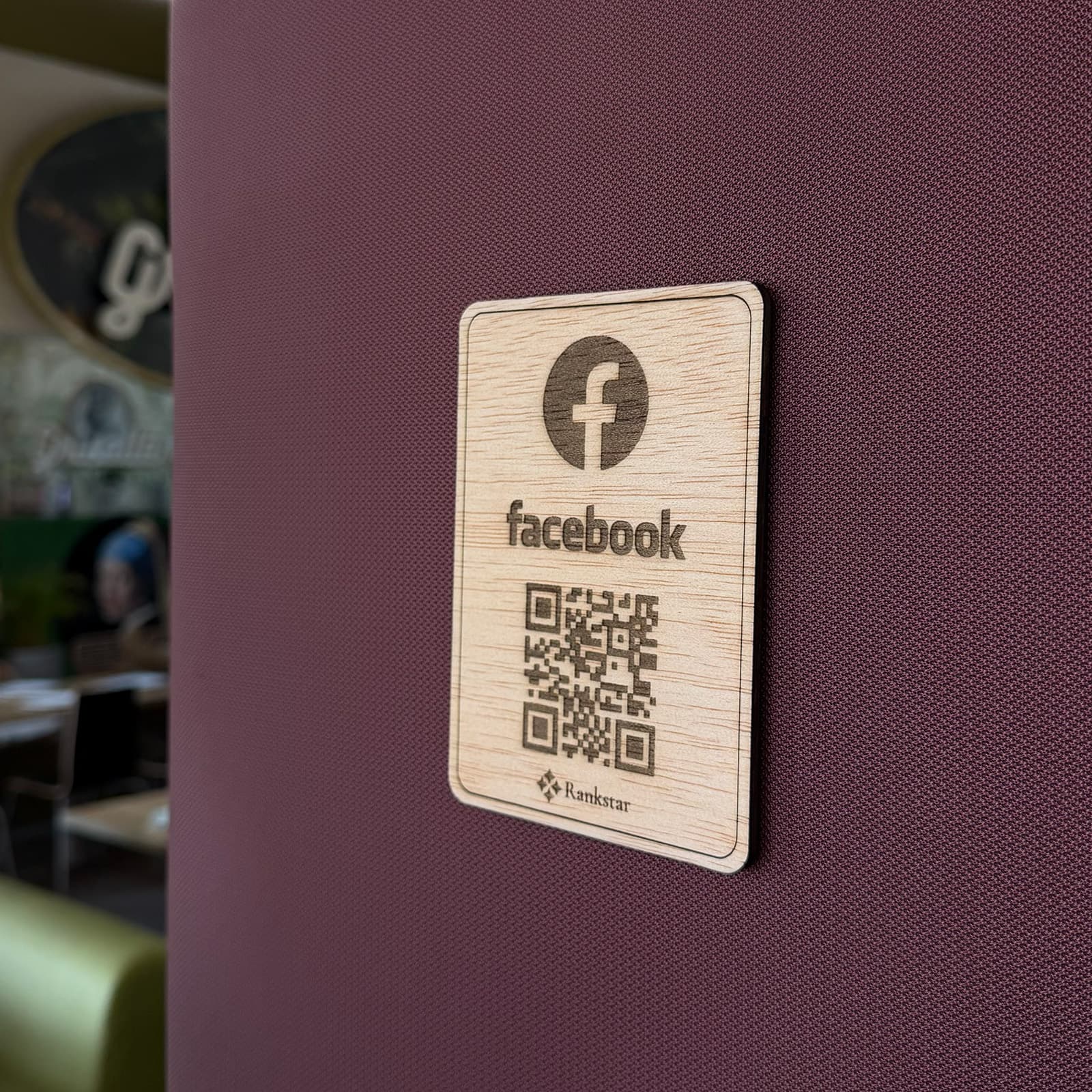 Placa Rankstar de Facebook pegada en la pared granate de un restaurante