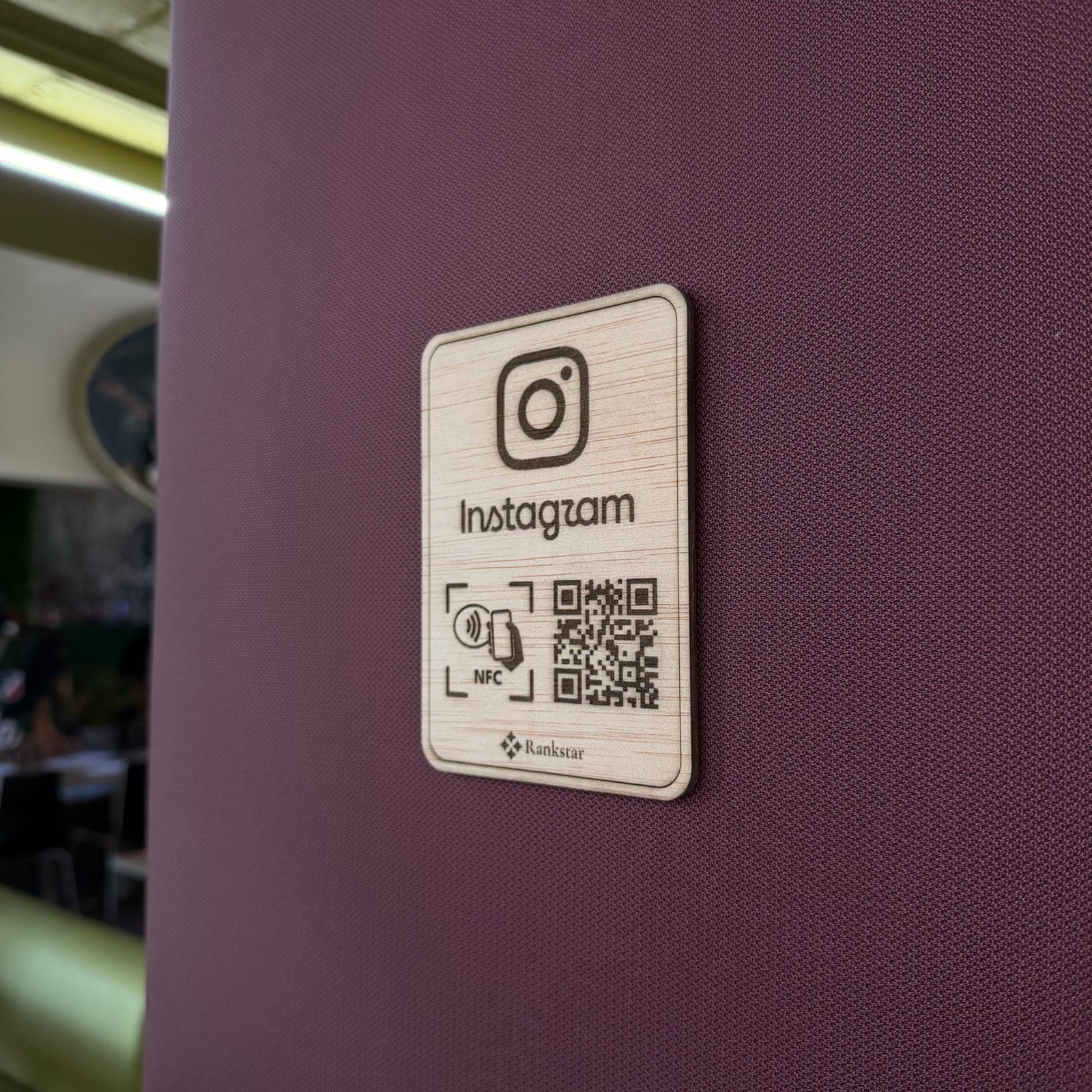 Placa Rankstar de Instagram pegada en la pared granate de un restaurante