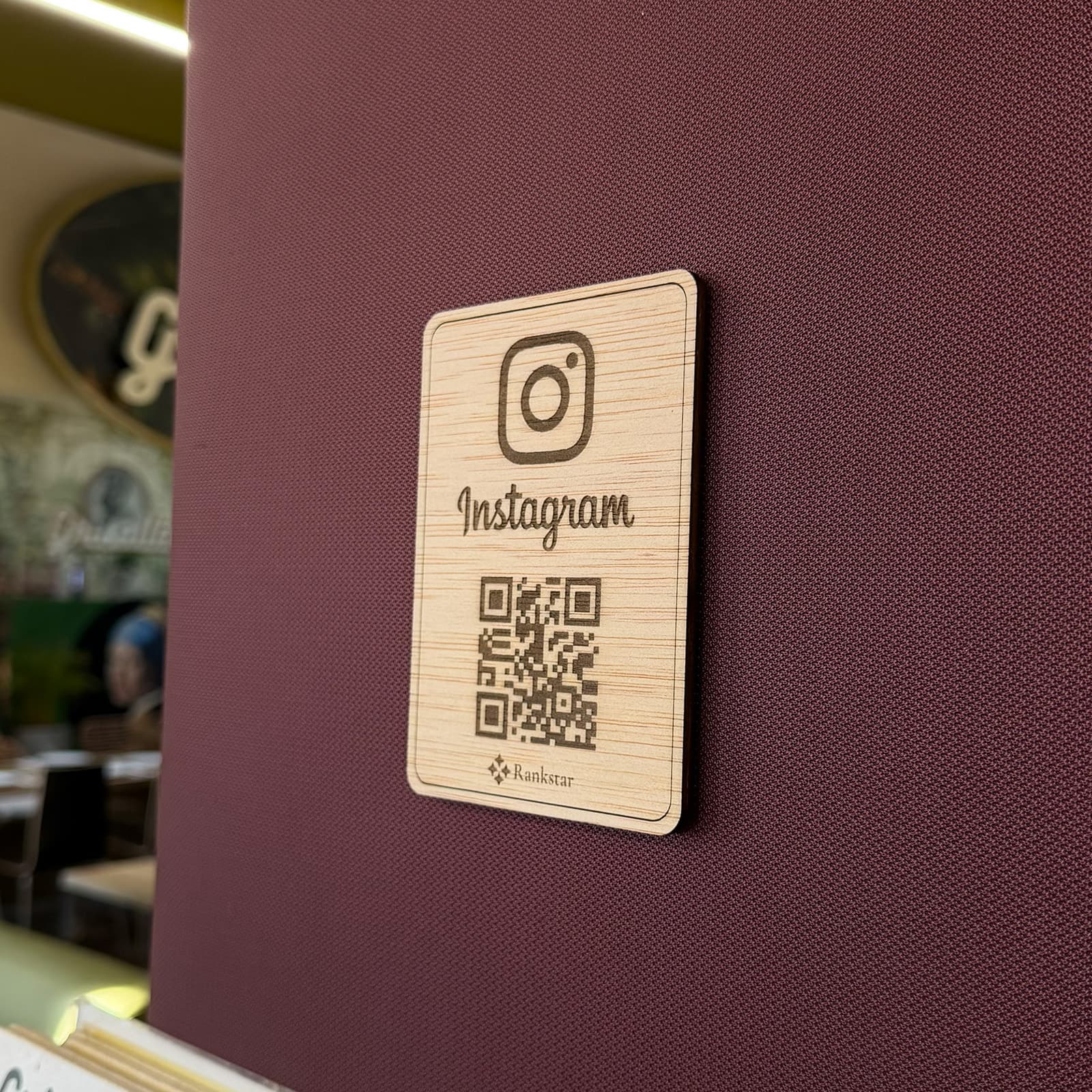 Placa Rankstar de Instagram pegada en la pared granate de un restaurante