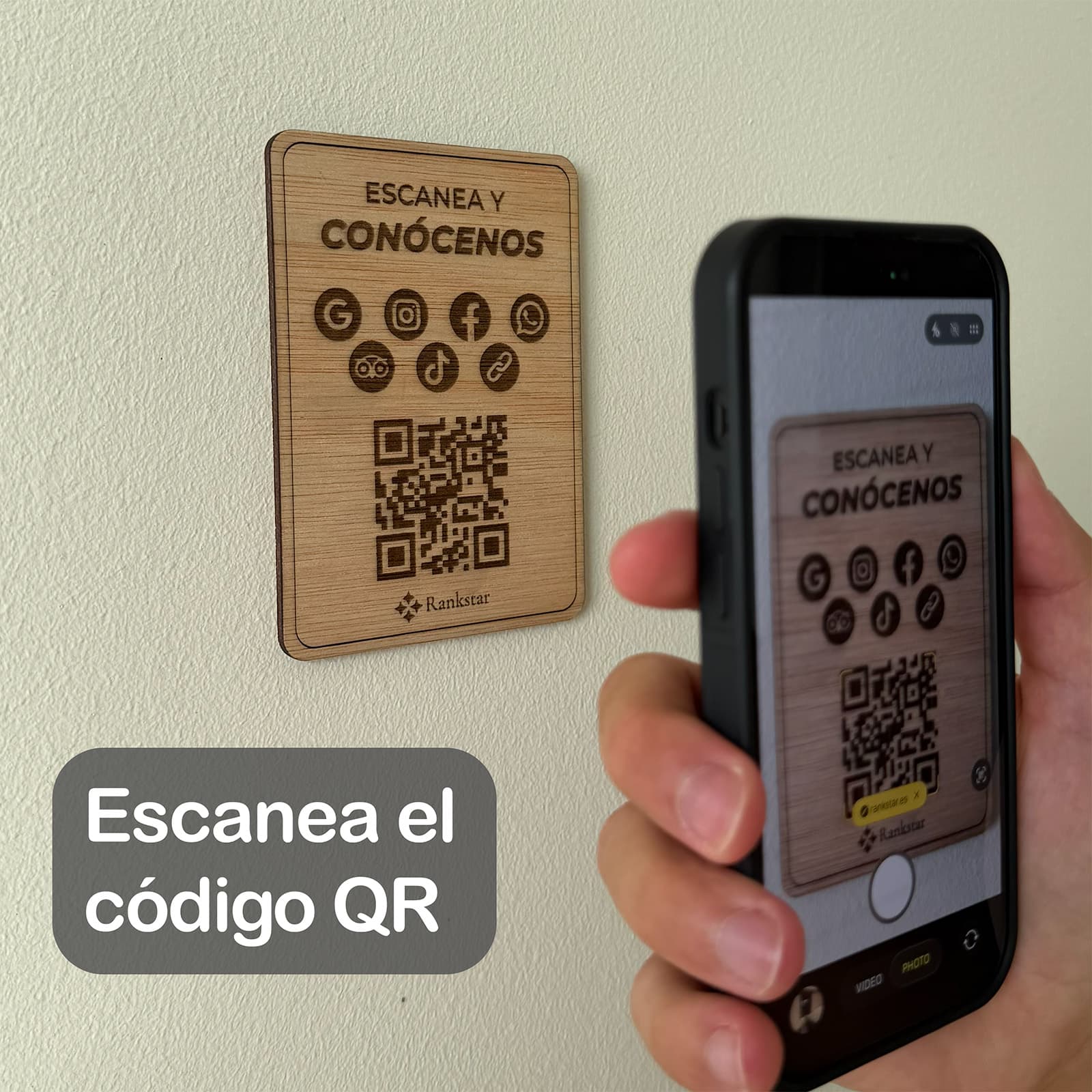Una mano escanea con el móvil el QR de la placa Rankstar Multilink pegada en una pared, con el rótulo «Escanea el código QR»