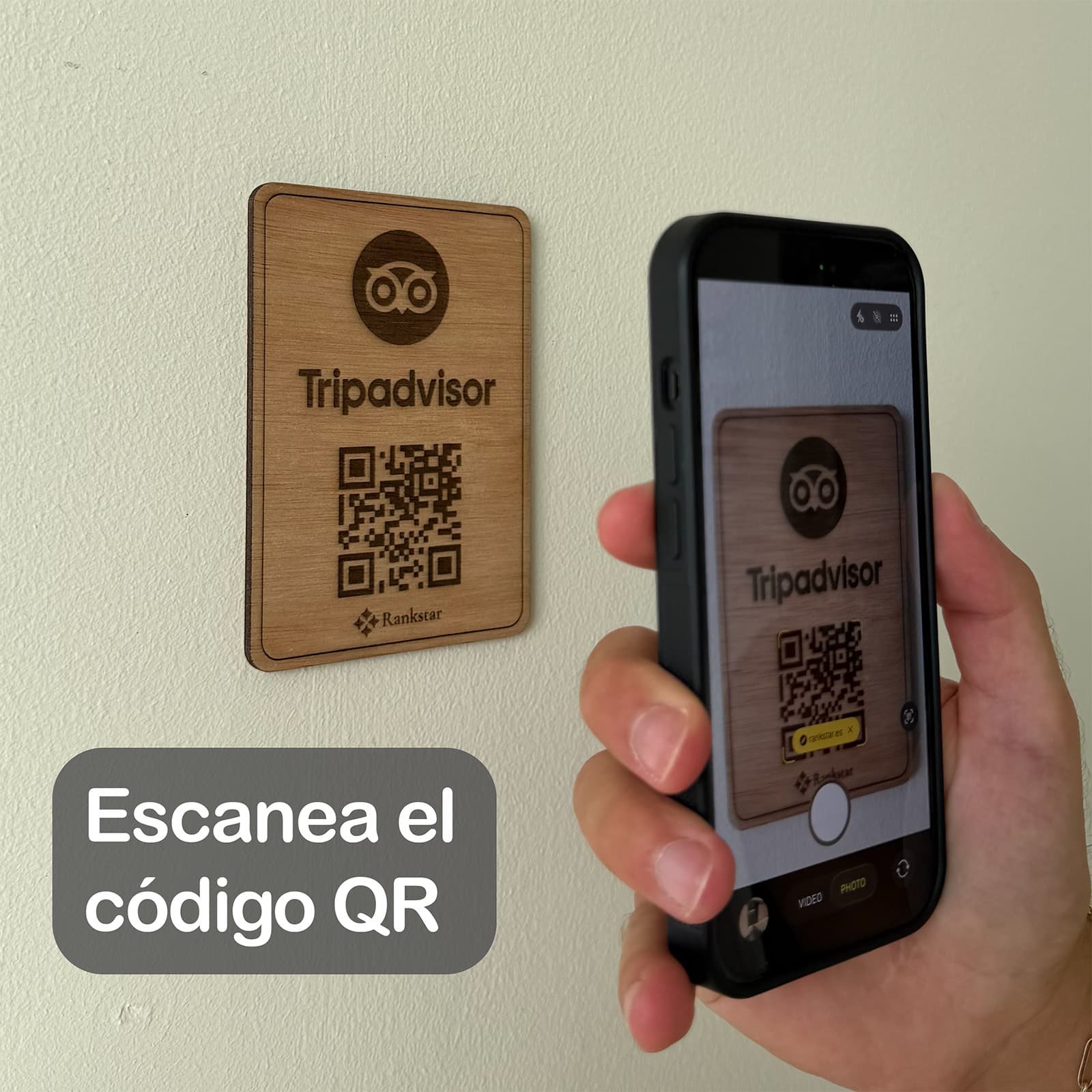 Una mano escanea con el móvil el QR de la placa Rankstar de Tripadvisor pegada en una pared, con el rótulo «Escanea el código QR»