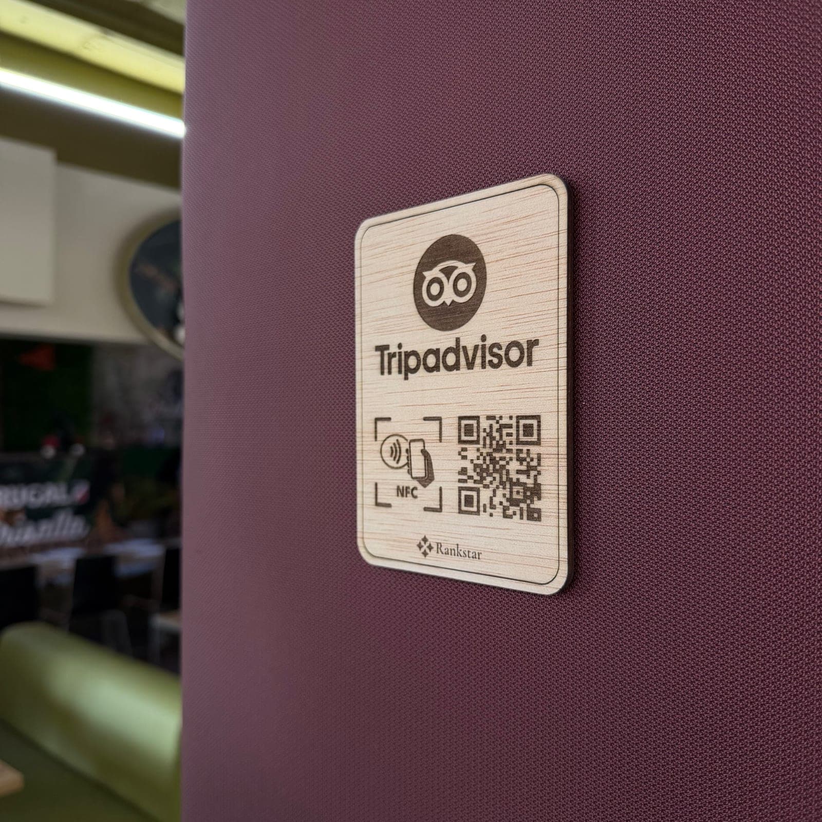Placa Rankstar de Tripadvisor pegada en la pared granate de un restaurante