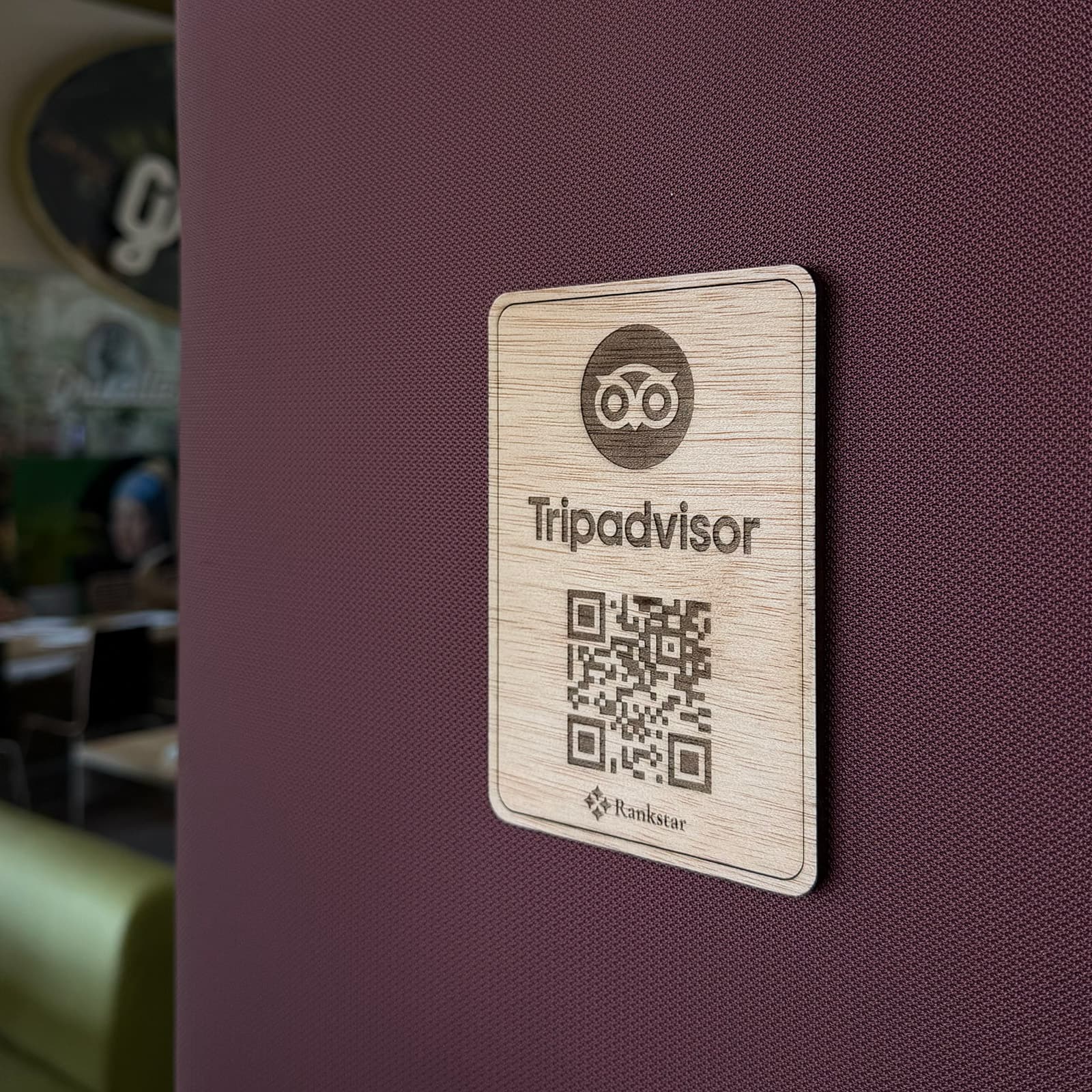 Placa Rankstar de Tripadvisor pegada en la pared granate de un restaurante