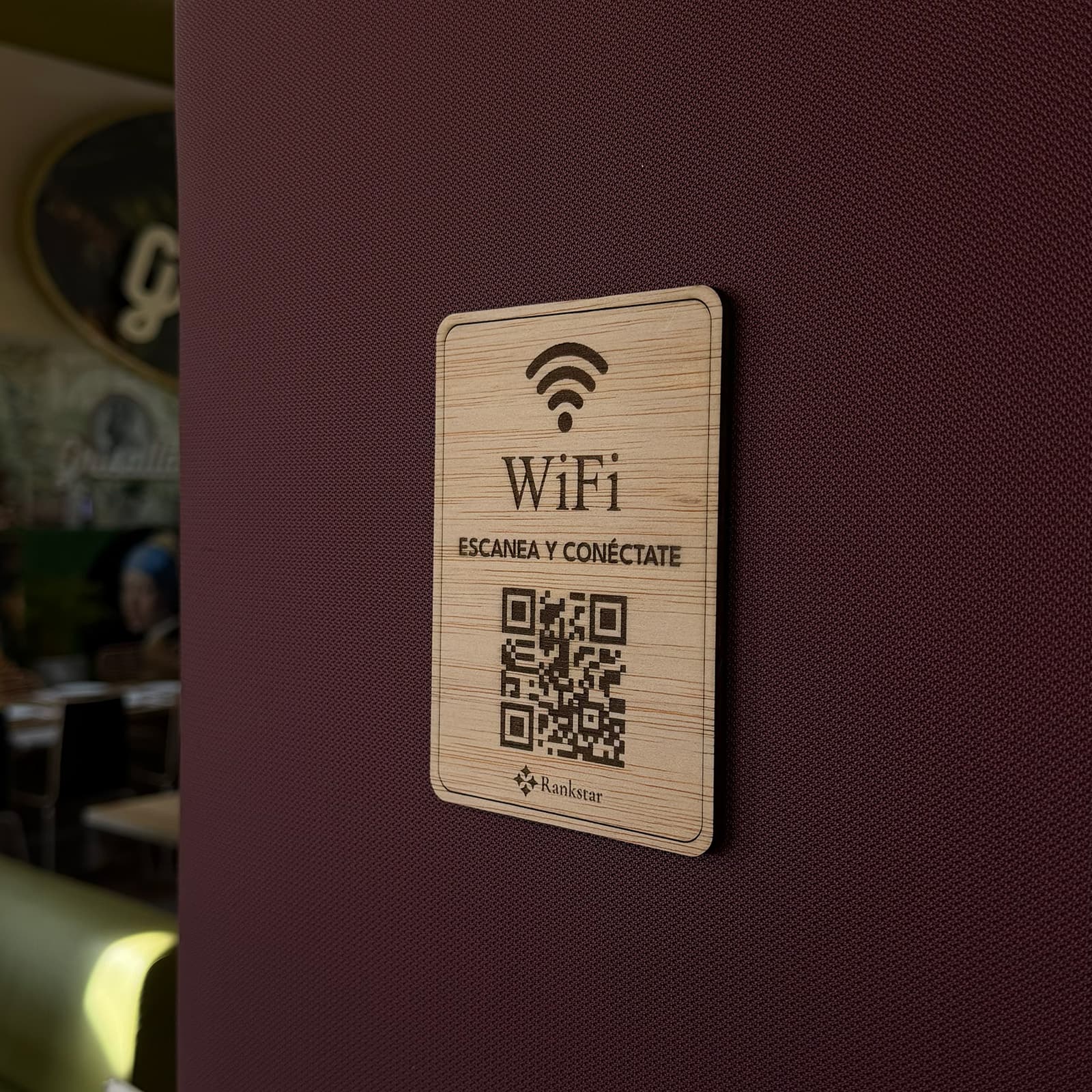 Placa Rankstar de WiFi pegada en la pared granate de un restaurante